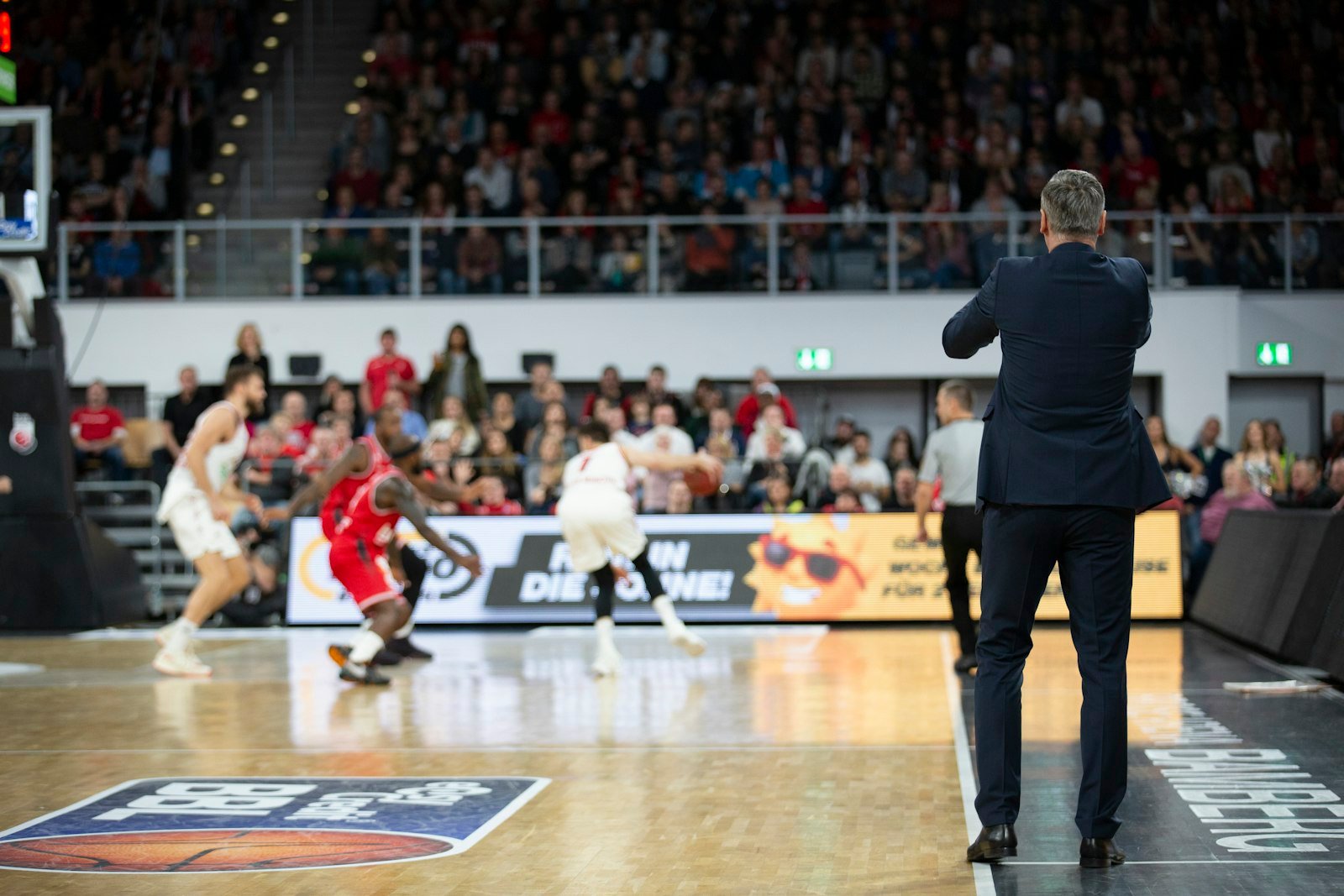Jogadores de basquete em movimento durante uma partida, cena típica fotografada em modo de disparo contínuo (burst)