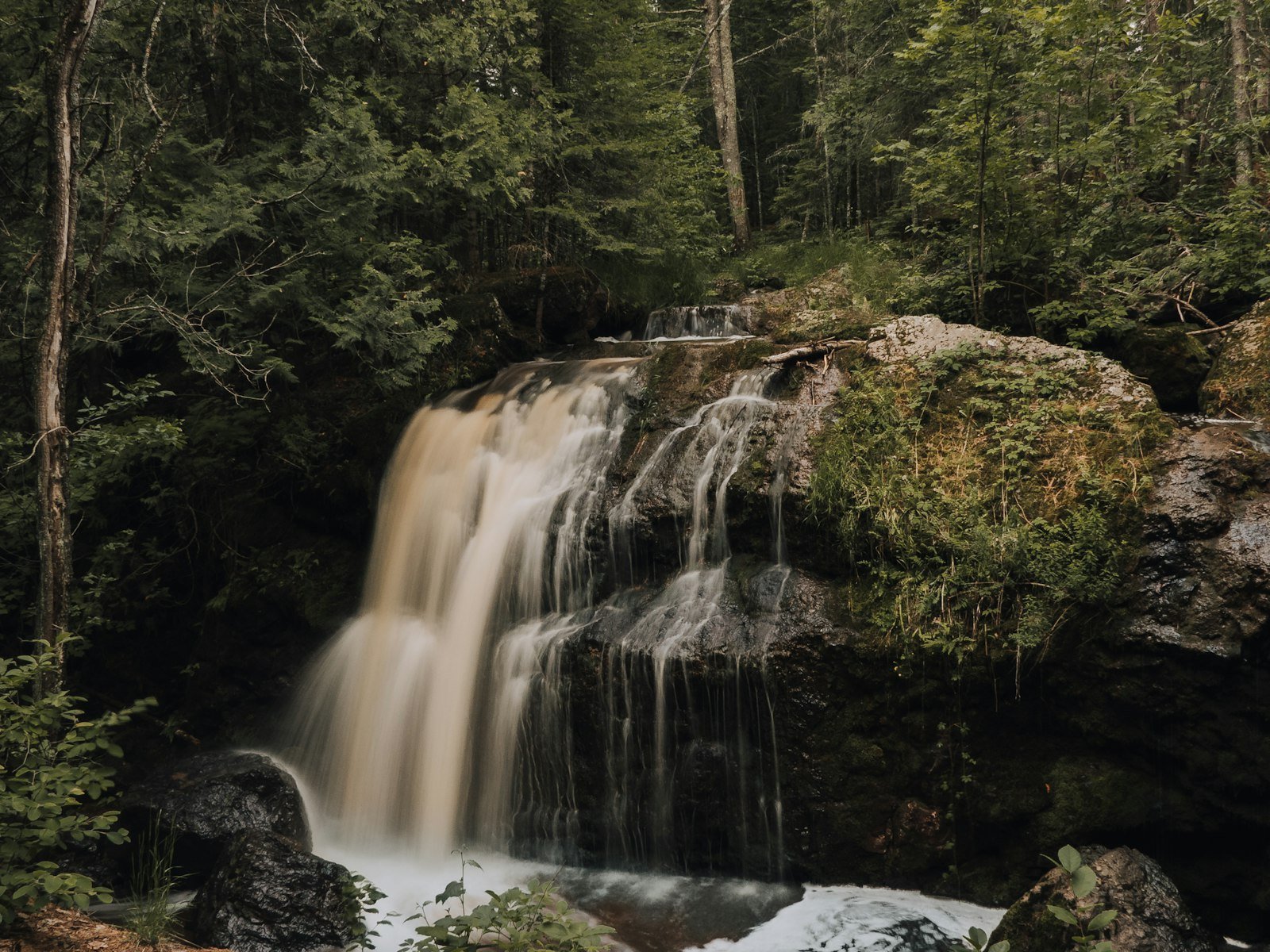 Cachoeira na floresta fotografada em longa exposição, com a água em efeito sedoso característico dessa técnica
