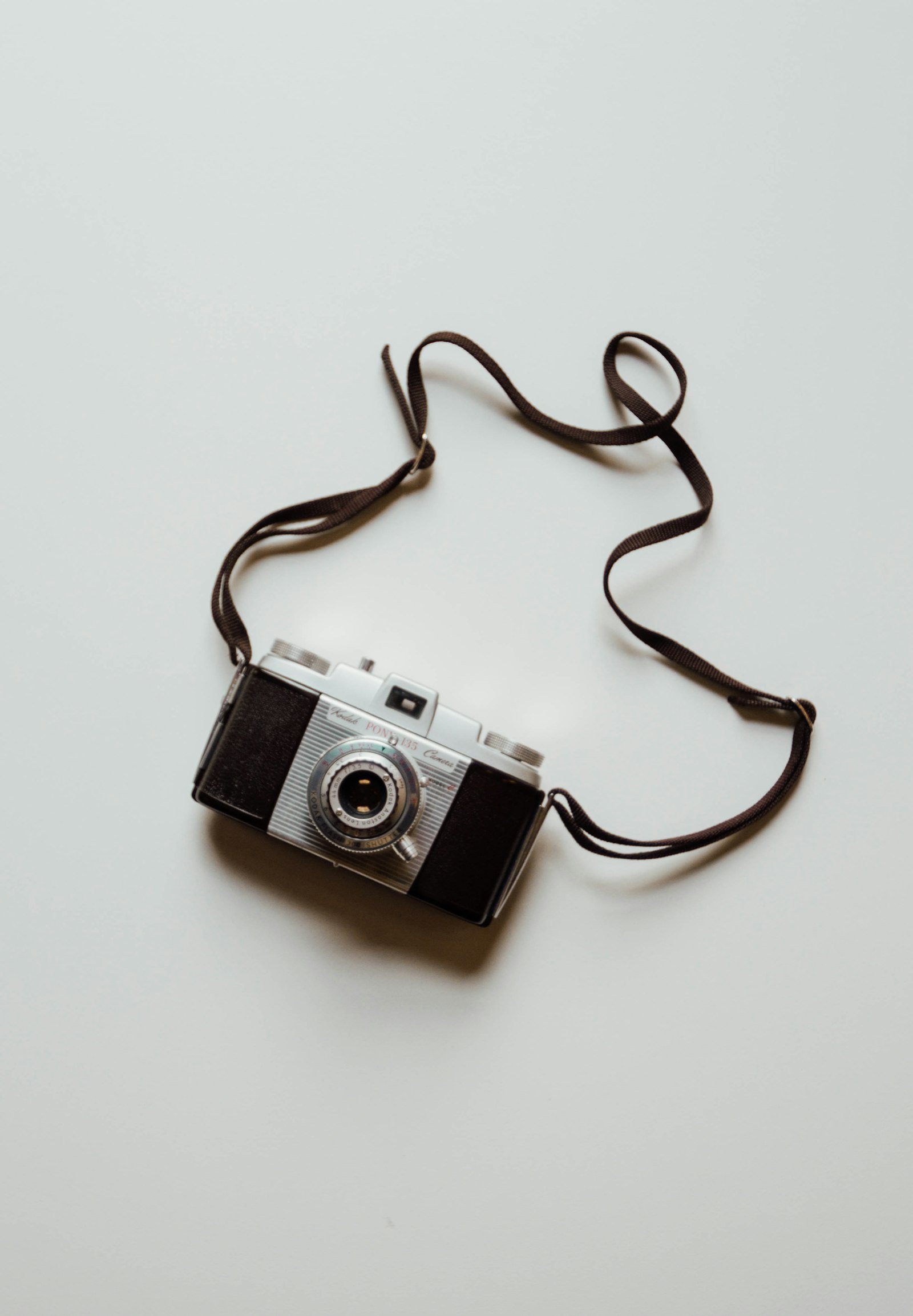 Câmera vintage compacta com alça, representando a evolução dos equipamentos fotográficos portáteis